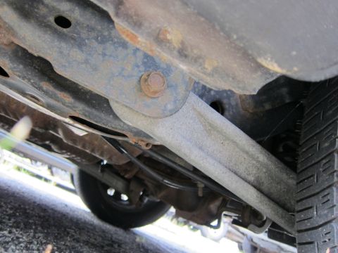 2001 Ford Crown Victoria - A close-up shot reveals the undercarriage of a vehicle, highlighting its suspension system and a tire.