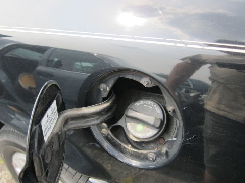 2001 Ford Crown Victoria - Fuel filler door and cap on a black vehicle, with instructions visible.
