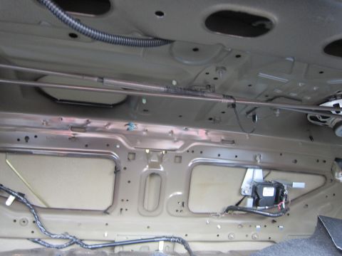 2001 Ford Crown Victoria - The underside of a vehicle's trunk reveals structural components and wiring harnesses.