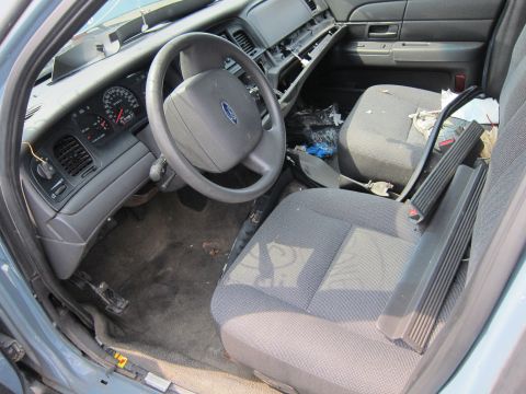 2001 Ford Crown Victoria - The interior of a 2001 Ford Crown Victoria shows a dirty dashboard and seats, indicating a state of disrepair.