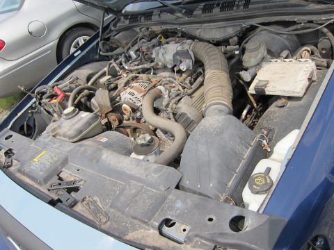 2001 Ford Crown Victoria - Engine bay of a blue car, with another car visible in the background.