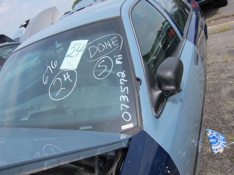 2001 Ford Crown Victoria - A two-tone sedan sits in a lot with handwritten markings on its windshield.