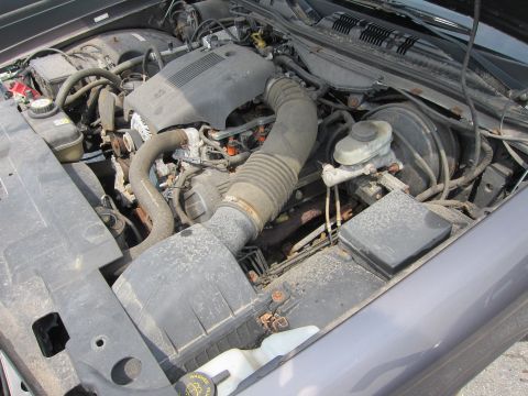 2001 Ford Crown Victoria - The engine compartment of a vehicle is shown, with various hoses and components visible.