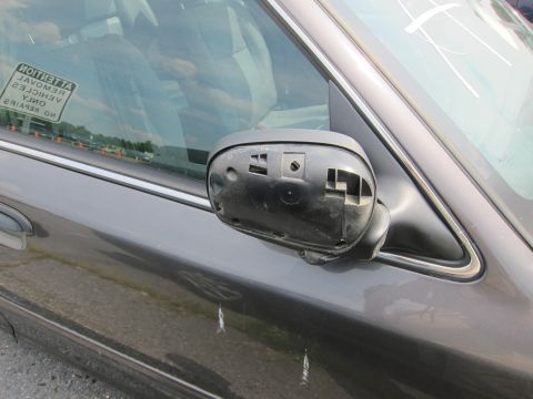2001 Ford Crown Victoria - Side view of a dark sedan with a missing side mirror housing. A sticker on the window indicates 'NO REPAIRS ON VEHICLES'.