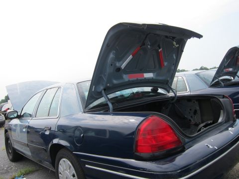 2001 Ford Crown Victoria - A dark blue 2001 Ford Crown Victoria is seen with its trunk and hood open, parked next to another vehicle.