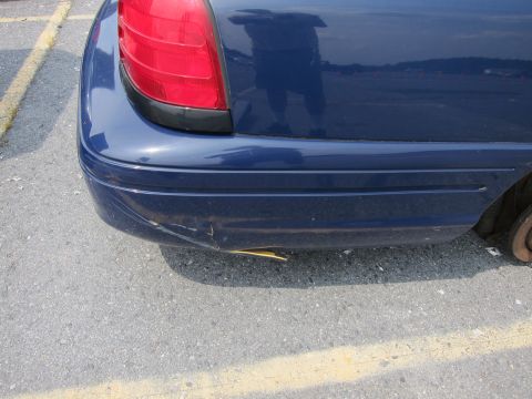 2001 Ford Crown Victoria - Rear view of a blue 2001 Ford Crown Victoria showing damage to the bumper.
