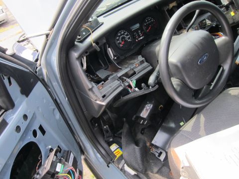 2001 Ford Crown Victoria - The dashboard of a vehicle is partially dismantled, revealing internal components and wiring.