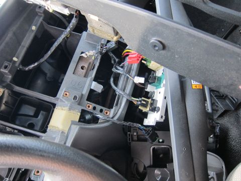 2001 Ford Crown Victoria - Close-up view of the exposed wiring and electrical connectors within a vehicle's dashboard.