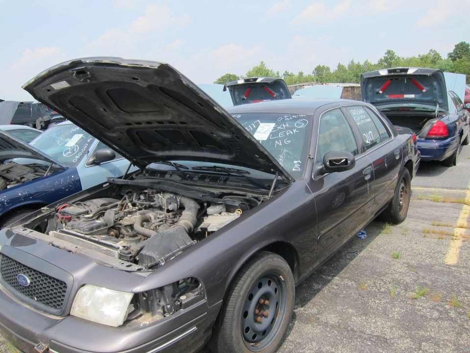 Dark gray 2001 Ford Crown Victoria with hood open, showing engine and front end damage