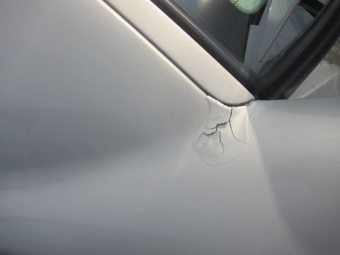2001 Ford Crown Victoria - Paint damage is visible on the upper corner of the door frame, near the window seal.