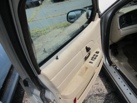 2001 Ford Crown Victoria - Interior view of a 2001 Ford Crown Victoria's driver's side door panel, showing beige trim and controls.
