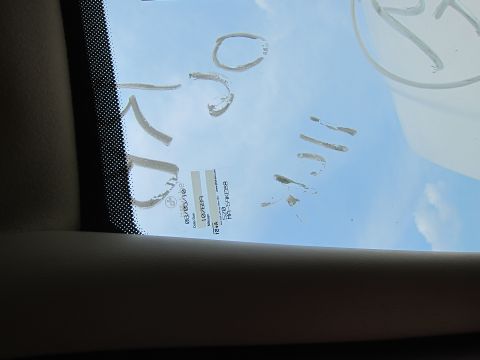 2001 Ford Crown Victoria - View through a car windshield shows handwritten markings and a service sticker with date and mileage information.