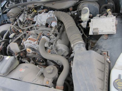 2001 Ford Crown Victoria - Engine bay components including hoses, belts, and electrical parts are dusty and appear worn.