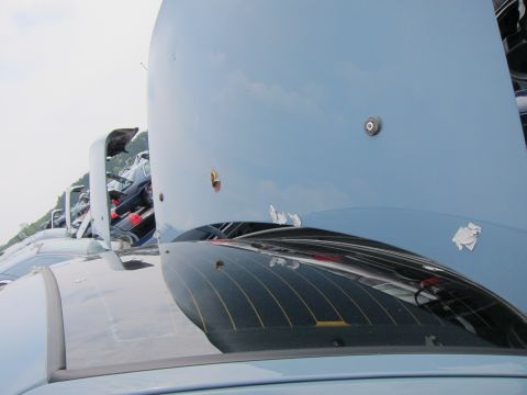 2001 Ford Crown Victoria - A light blue car hood is open, revealing damage and a camera mount, with other vehicles visible in the background.