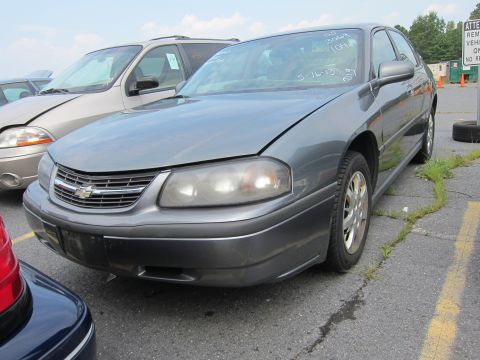 2001 Ford Crown Victoria - Front view of a gray Chevrolet Impala, parked outdoors with other vehicles nearby.