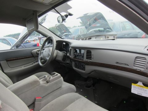 2001 Ford Crown Victoria - The interior of a Chevrolet Impala shows a cracked dashboard and a warning sticker, with other vehicles visible outside.