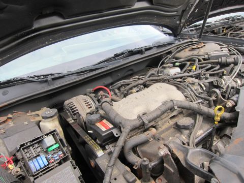 2001 Ford Crown Victoria - Close-up view of a vehicle's engine bay, showing various mechanical parts and the fuse box.