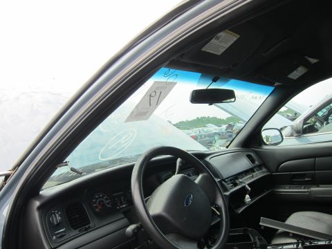 2001 Ford Crown Victoria - The interior of a 2001 Ford Crown Victoria is visible, with a sticker on the windshield and other vehicles in the background.