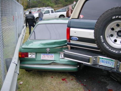 1995 Ford Bronco - Two vehicles involved in a collision, with one pushed against a fence.