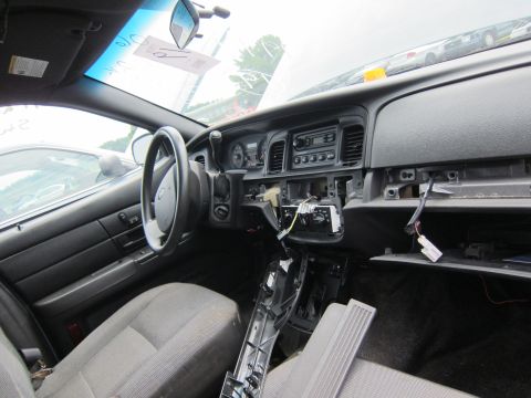 2001 Ford Crown Victoria - The interior of a car shows a disassembled dashboard with exposed wiring and components.