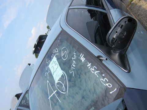 2001 Ford Crown Victoria - Chalk markings on the windshield of a light blue car indicate 'STARTER' and mileage, with an item number visible.