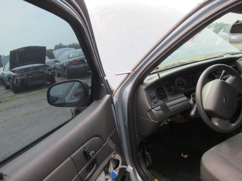 2001 Ford Crown Victoria - View from the driver's seat of a car in a junkyard, with other vehicles in the background.