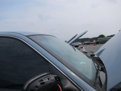 2001 Ford Crown Victoria - A light blue 2001 Ford Crown Victoria is parked with its hood open, alongside other vehicles under a cloudy sky.