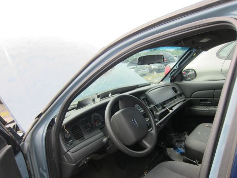 2001 Ford Crown Victoria - The interior of a 2001 Ford Crown Victoria is visible, with the dashboard, steering wheel, and seats in view, along with other vehicles in…
