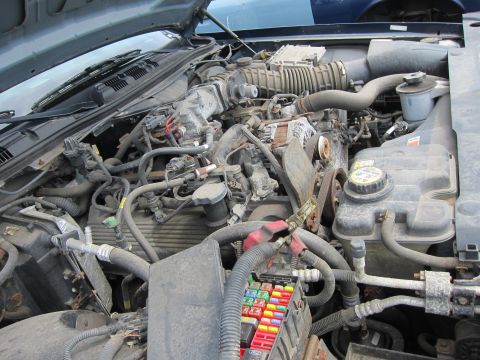 2001 Ford Crown Victoria - The engine compartment of a vehicle, showing a complex arrangement of mechanical and electrical components.