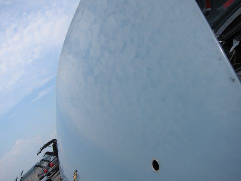 2001 Ford Crown Victoria - The smooth, curved surface of a car's hood reflects the cloudy sky above.