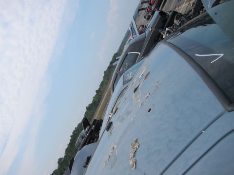 2001 Ford Crown Victoria - Multiple vehicles are parked in a lot under a cloudy sky.