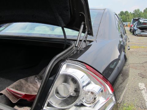 2001 Ford Crown Victoria - Rear view of a sedan with its trunk open, parked outdoors with other vehicles nearby.