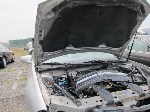 2001 Ford Crown Victoria - Engine bay of a silver car, with hood open. Another vehicle is parked nearby.