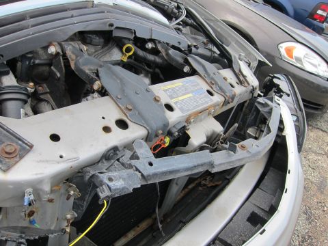2001 Ford Crown Victoria - The engine compartment of a vehicle is shown, with a second car visible in the background.