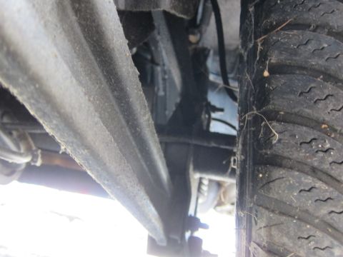 2001 Ford Crown Victoria - A close-up view of a vehicle's undercarriage, focusing on the tire and suspension system.