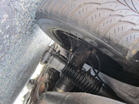2001 Ford Crown Victoria - Undercarriage view of a vehicle, focusing on the tire and steering components.