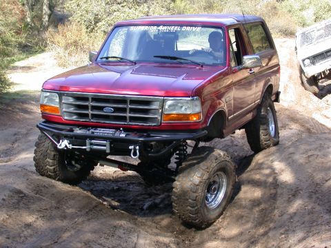1996 Ford Bronco - This modified Ford Bronco navigates a challenging off-road course, its enhanced suspension and all-terrain capabilities.