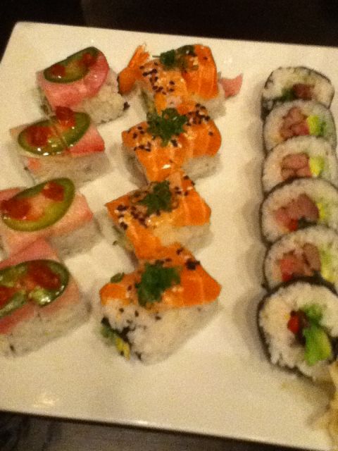 2006 Ford E350 - A white plate holds a variety of sushi, including nigiri topped with tuna and jalapeño, and maki rolls filled with salmon and avocado.