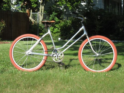 1994 Ford Bronco - A custom bicycle with a unique frame design and bright orange tires sits on a grassy lawn.