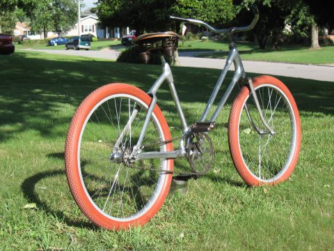 1994 Ford Bronco - A vintage-style bicycle with bright orange tires is parked on a grassy lawn.