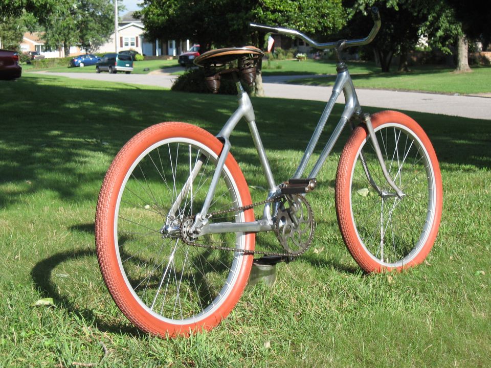 Silver bicycle with orange tires on grass
