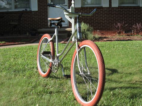 1994 Ford Bronco - A bicycle with orange tires is parked on a lawn in front of a house.