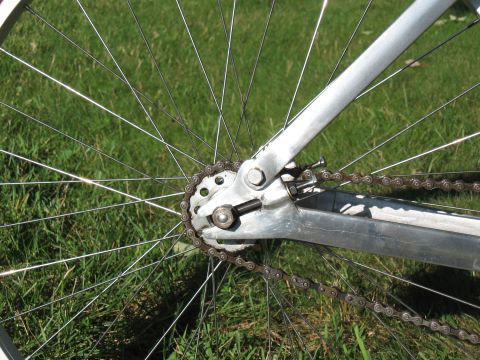1994 Ford Bronco - Close-up view of a bicycle's rear wheel, chain, and cogset on a grassy surface.