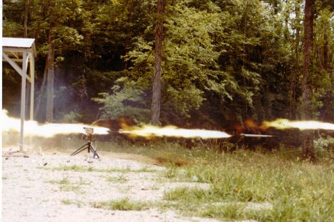 1978 Ford F-250 - A powerful muzzle flash erupts from a firearm during a test or demonstration in an outdoor setting.