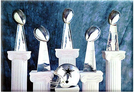 1988 Ford Bronco - Collection of Vince Lombardi trophies and a Dallas Cowboys helmet displayed together.