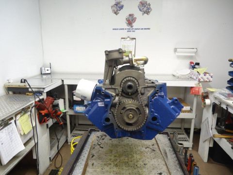 1982 Ford Bronco - A blue engine block is suspended in a workshop, showing its internal timing components.