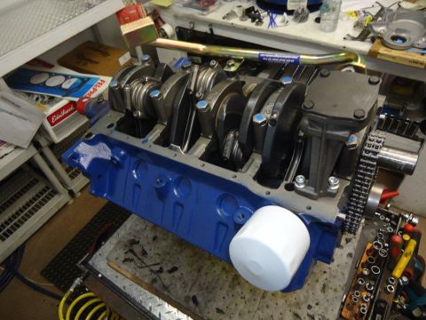 1982 Ford Bronco - Engine block assembly with crankshaft visible. Tools and parts are scattered around the workspace.