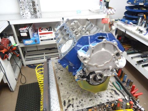 1982 Ford Bronco - A disassembled engine sits on a workbench, surrounded by tools and engine components.