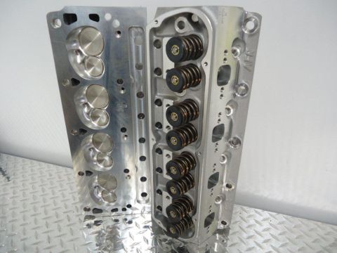 1982 Ford Bronco - Two aluminum engine cylinder heads are shown, one with intake valves and the other with valve springs.