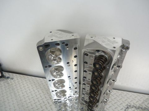 1982 Ford Bronco - Two aluminum engine cylinder heads are displayed, showing internal components like valves and springs.